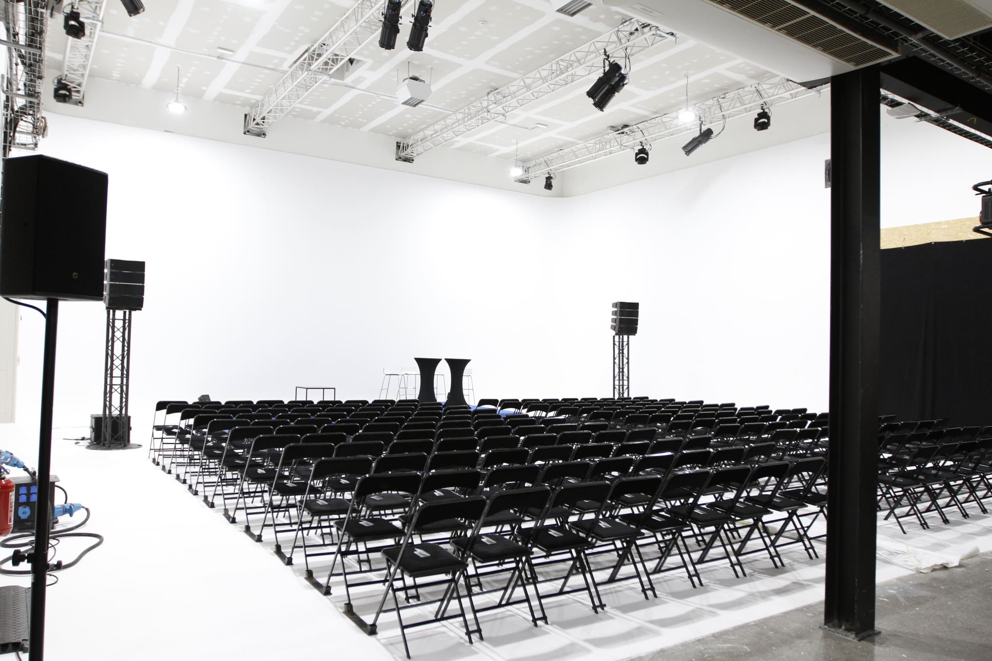 Un studio photo très grand avec des chaises et du matériel de prise de vue hautement professionnel